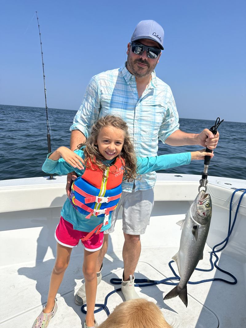 A young angler and dad with a catch on a family fishing charter