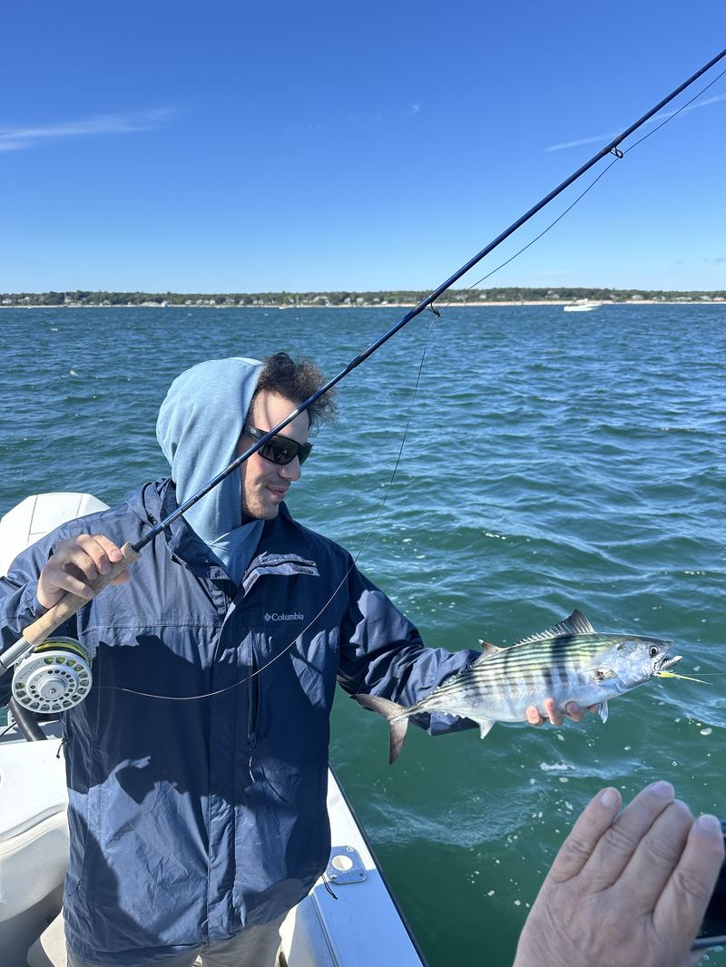 Angler fighting a striped bass on the fly in Boston Harbor