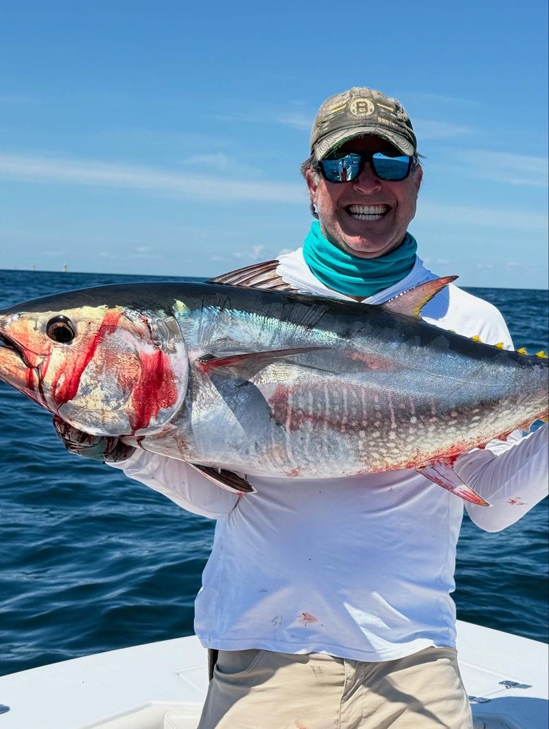Angler holding a false albacore caught on the fall run