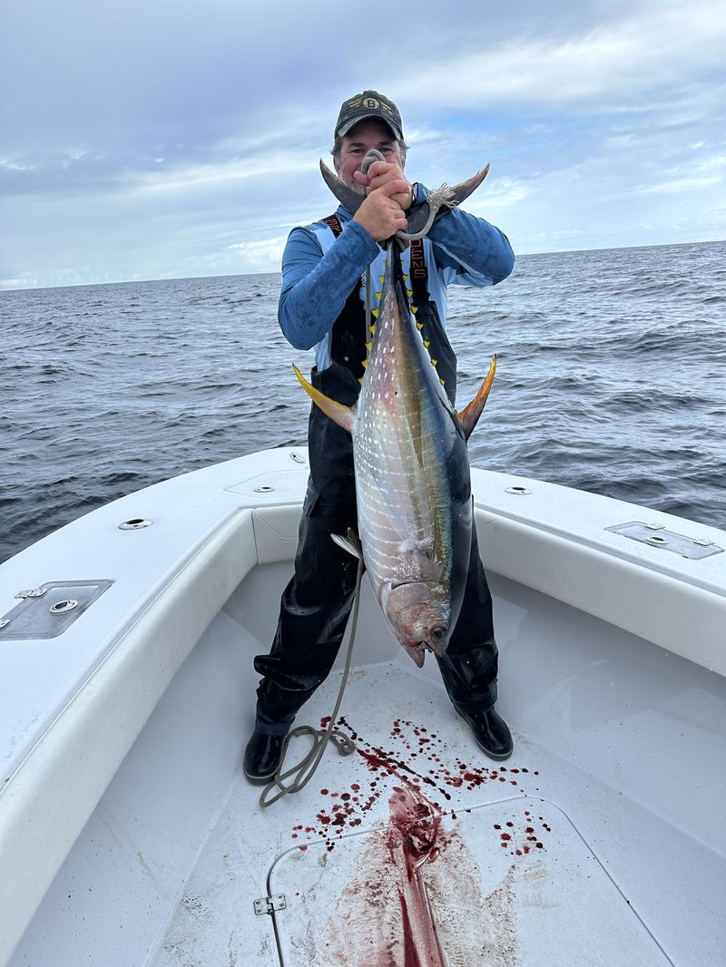 Angler in bibs with a bluefin tuna caught offshore