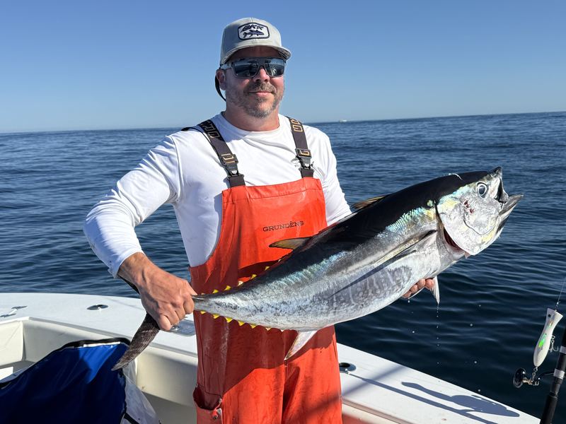 Angler in bibs with a false albacore caught off Cape Cod
