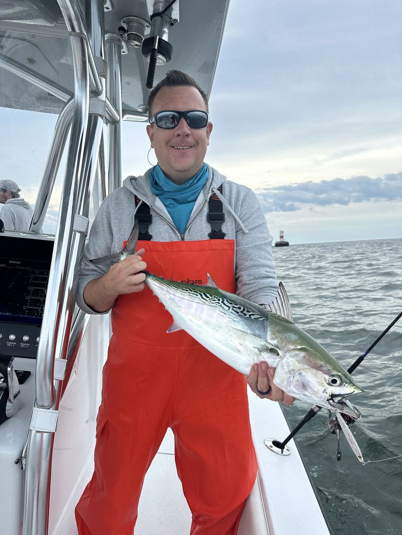 Angler in bibs with a false albacore off Cape Cod