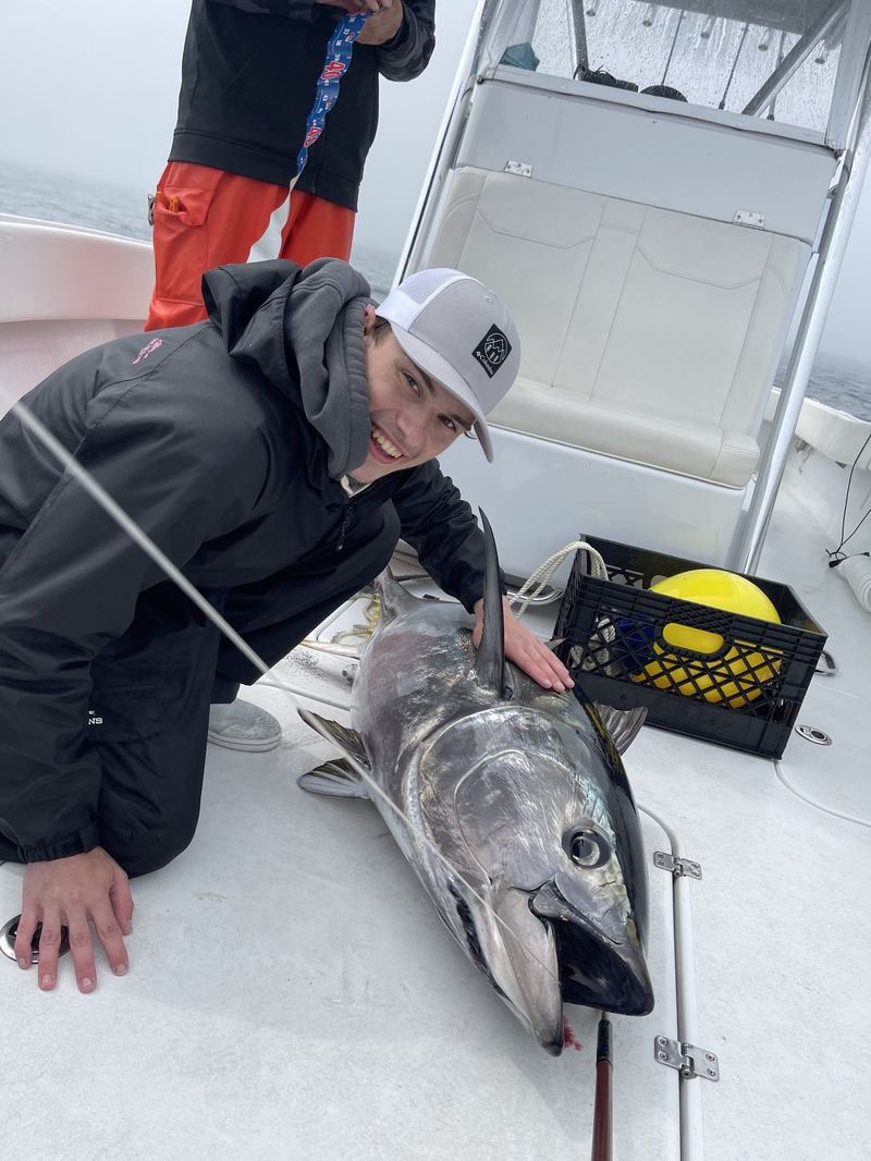 Angler with a bluefin tuna on the deck caught offshore of Cape Cod