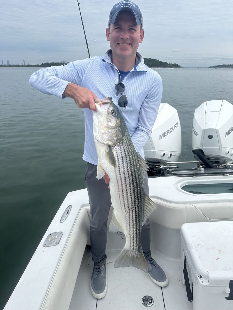 Angler with a striped bass on the Conch 27 in Boston Harbor